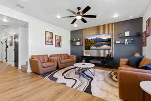 Living area with wood finished floors, a ceiling fan, and recessed lighting