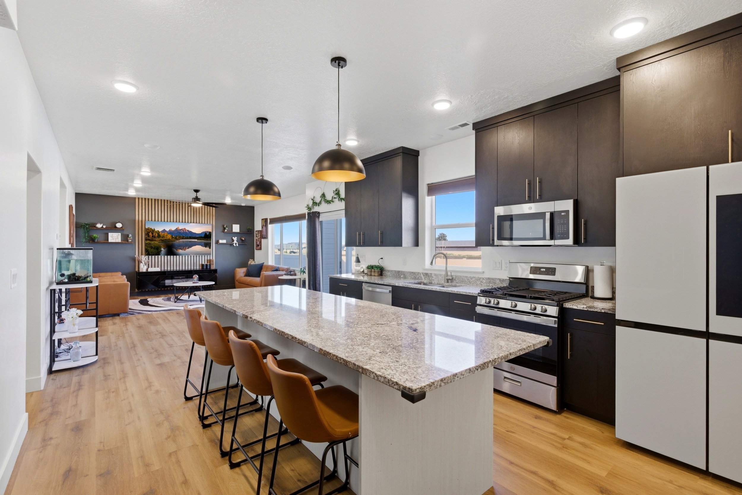 Kitchen featuring light stone counters, stainless steel appliances, a center island, a breakfast bar, and open floor plan