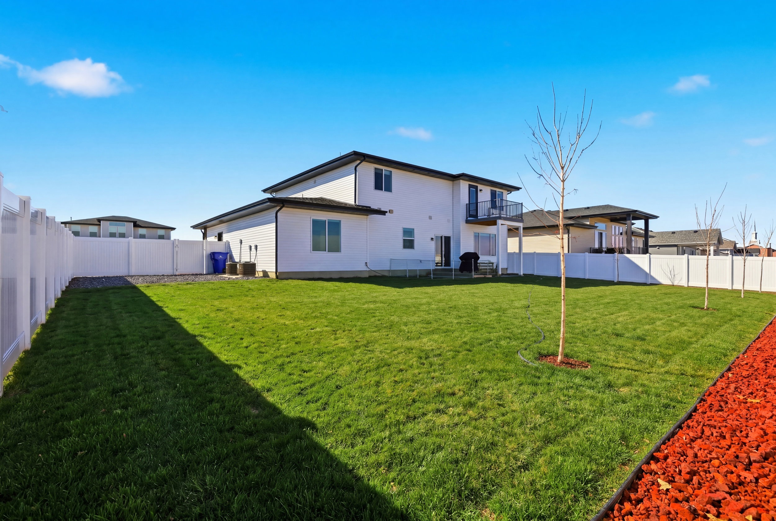 Grass Virtually Added - Back of property featuring a fenced backyard, a patio, and a balcony