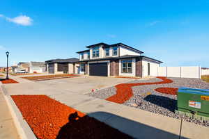 View of front of property with driveway, a garage, and brick siding