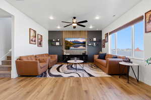 Living room with ceiling fan, light wood finished floors, and recessed lighting