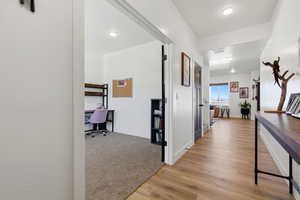 Hall featuring an office area, light wood-type flooring, and recessed lighting