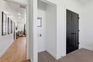 Hall with light carpet and recessed lighting