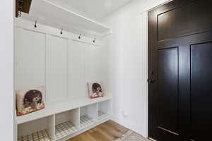 Mudroom featuring light wood-style floors and baseboards