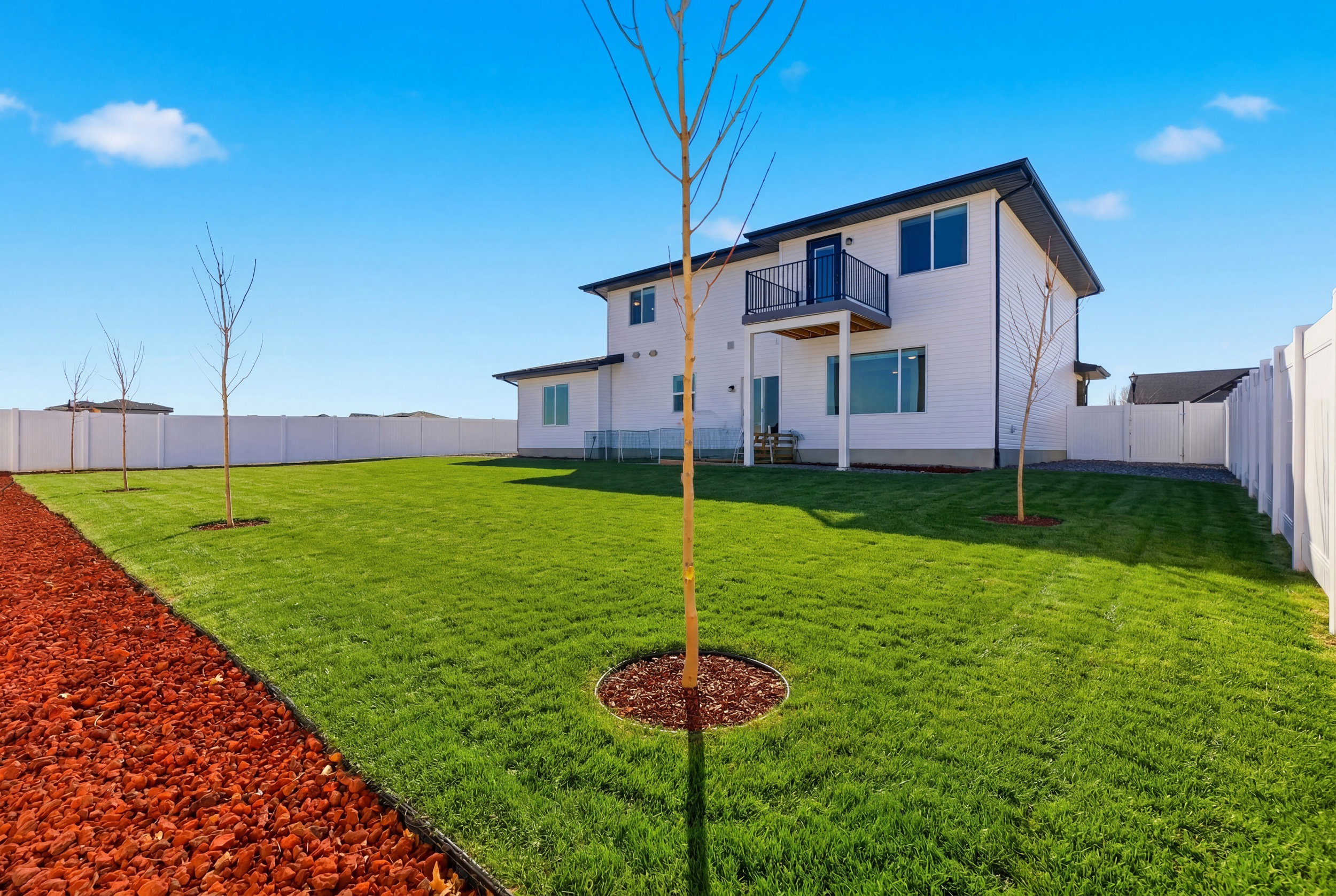 Grass Virtually Added - Rear view of house featuring a balcony and a fenced backyard