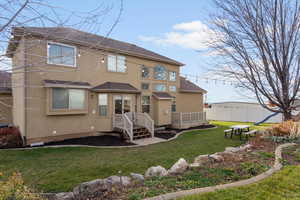 Back of property with a shingled roof and stucco siding