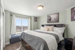 Bedroom with dark colored carpet and baseboards