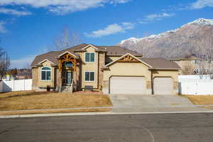 View of front of property featuring stucco siding, an attached garage, concrete driveway, stone siding, and a gate