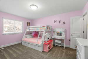 Bedroom with dark carpet and baseboards