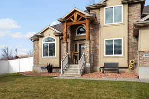 Property entrance with stone siding and stucco siding