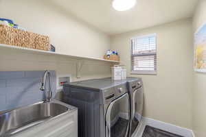 Laundry area with washer and clothes dryer and baseboards