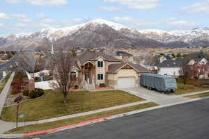 Traditional home featuring stucco siding, a mountain view, concrete driveway, a residential view, and a garage