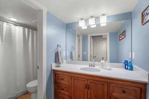 Bathroom featuring vanity, curtained shower, and tile patterned flooring