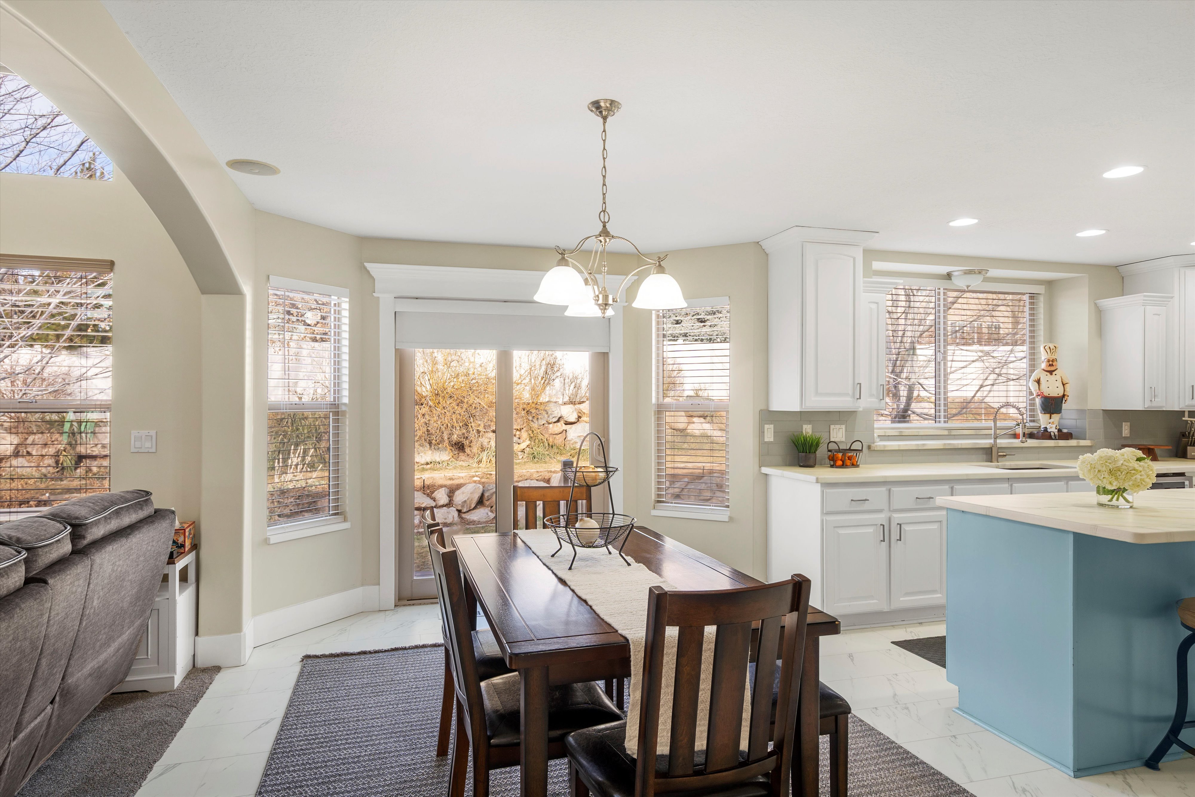 Dining room featuring hanging lights, light marble finish flooring, and arched walkways