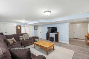 Living room with baseboards and light wood-style flooring