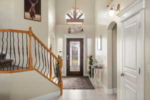 Foyer entrance with a chandelier, a high ceiling, and arched walkways