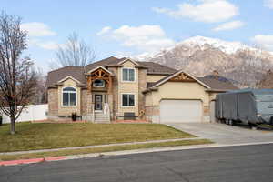 Craftsman-style home with stucco siding, a garage, driveway, and a mountain view