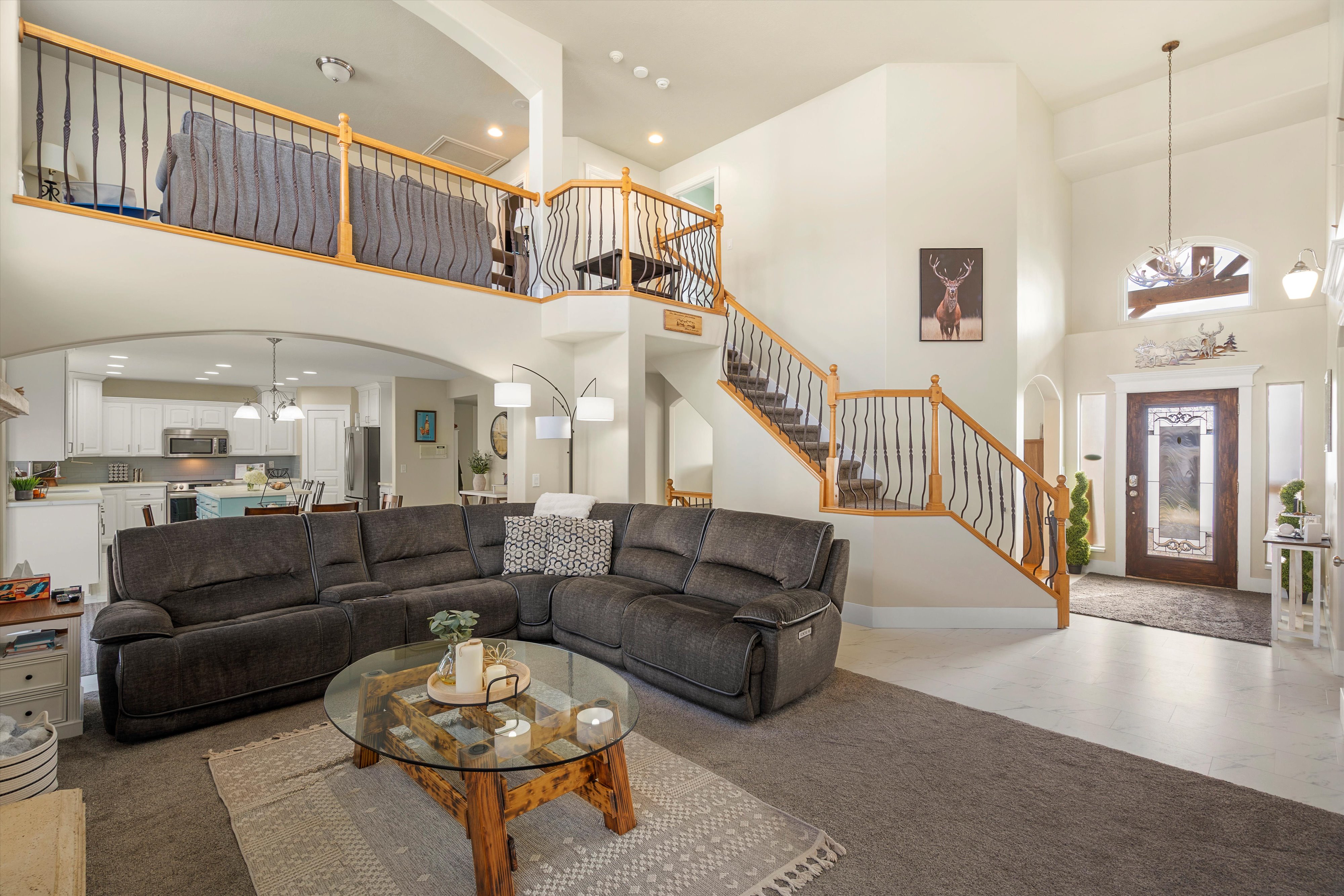 Living room with arched walkways, a chandelier, carpet flooring, and a high ceiling