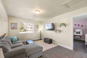 Living area with baseboards and carpet floors