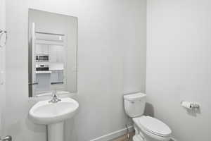 Half bath featuring baseboards and toilet