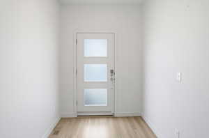Doorway to outside featuring wood finished floors and baseboards