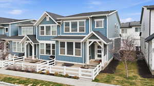 View of front of home with board and batten siding, a shingled roof, and a fenced front yard
