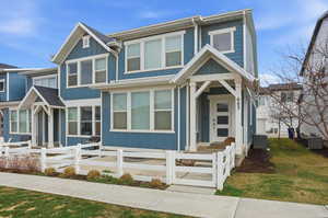 View of front facade featuring board and batten siding and a fenced front yard