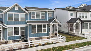 View of front of property featuring roof with shingles, board and batten siding, and a fenced front yard
