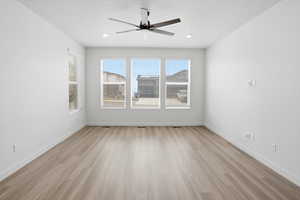 Unfurnished room with a ceiling fan and light wood-style flooring