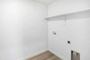 Laundry area featuring light wood finished floors, hookup for an electric dryer, and washer hookup