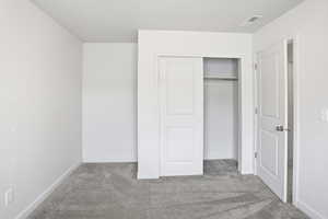 Unfurnished bedroom with carpet and a closet