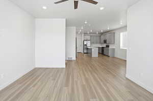 Unfurnished living room with light wood-style flooring, ceiling fan, and recessed lighting