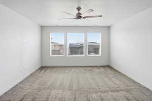 Empty room with light colored carpet, ceiling fan, and a textured ceiling