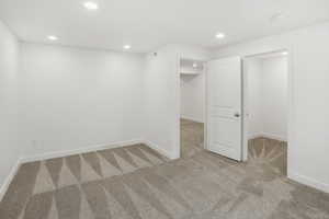 Basement with light carpet and recessed lighting
