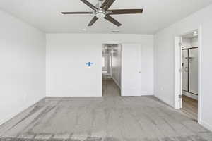 Unfurnished bedroom featuring light carpet, ceiling fan, and connected bathroom