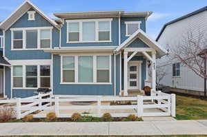 View of front of home with a fenced front yard and board and batten siding