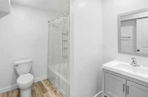 Full bath with vanity, light wood finished floors, and shower / bath combo