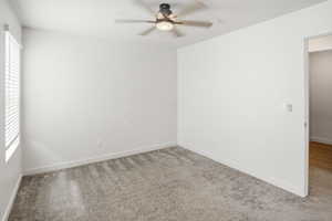 Unfurnished room with carpet and a ceiling fan
