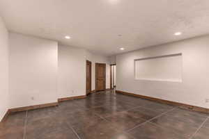 Empty great room featuring baseboards and recessed lighting