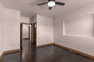 Unfurnished third bedroom with a ceiling fan and a textured wall