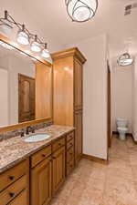 Bathroom with vanity, light tile patterned flooring, and a textured ceiling