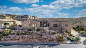 Mediterranean / spanish-style home with stucco siding, stone siding, and a chimney