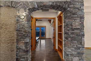 Corridor to Primary Suite with arched walkways and baseboards
