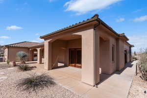 Rear view of house with stucco siding and a patio