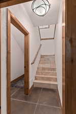 Staircase featuring concrete flooring and a textured wall