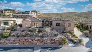 Mediterranean / spanish house featuring stucco siding, stone siding, and a patio area