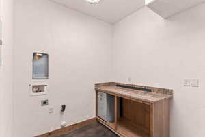 Laundry room featuring a textured wall, gas dryer hookup, washer hookup, finished concrete flooring, and electric dryer hookup