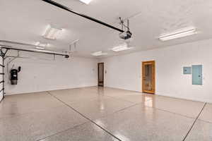 Garage featuring electric panel and a garage door opener