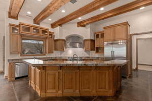 Kitchen with glass insert cabinets, finished concrete flooring, backsplash, a large island with sink, and recessed lighting