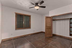 Unfurnished first bedroom featuring ceiling fan and a closet